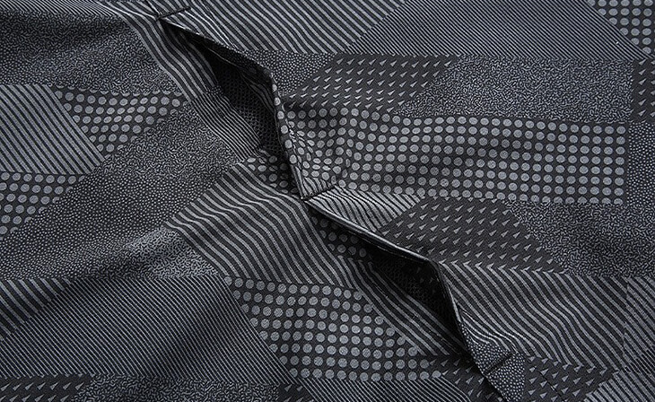 Close-up of men's mountaineering jacket fabric featuring geometric patterns for style and durability in outdoor adventures.