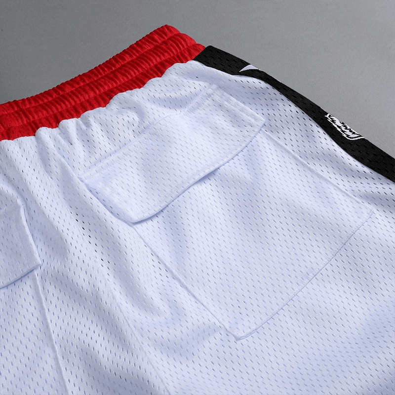 Close-up of men's quick-drying loose basketball shorts with red waistband and side pockets, perfect for running and sports.