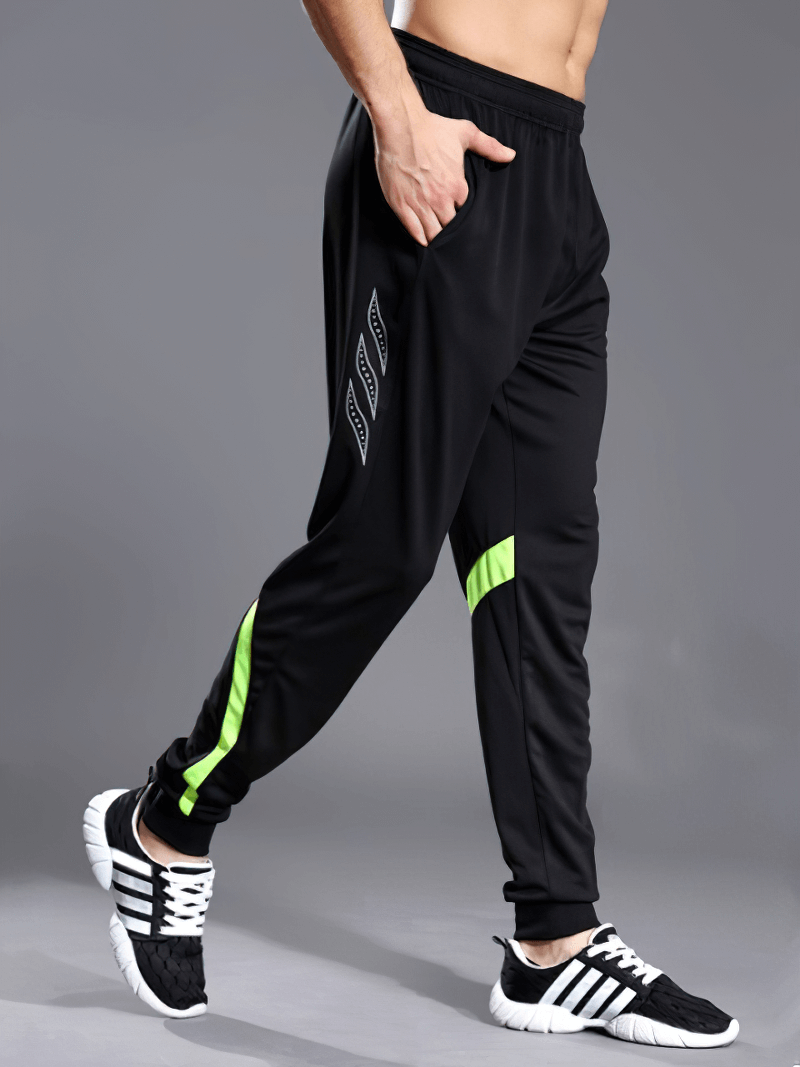 Men's polyester running sports pants with zipper pockets and elastic waist, featuring neon accents, modeled while walking.