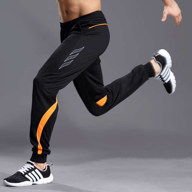 Men's running sports pants with zipper pockets for secure running, featuring orange accents and elastic waist, perfect for performance.