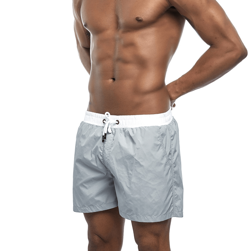 Men's quick dry swimming shorts in solid gray, perfect for beachwear and summer activities, made from lightweight polyester.
