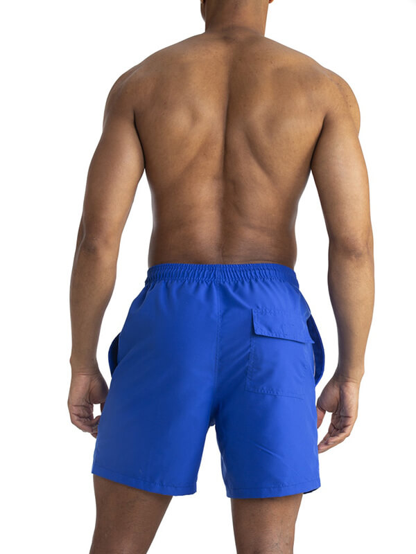Back view of a man wearing blue solid color boardshorts with pockets, showcasing a modern swimwear design for men.
