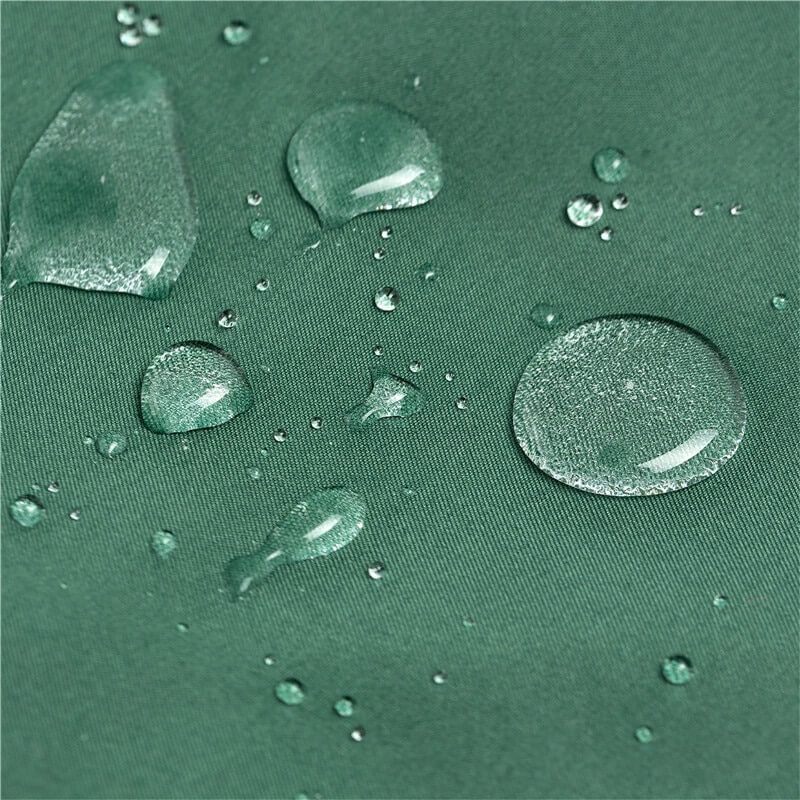 Close-up of water droplets on green waterproof polyester fabric, showcasing quick-drying feature of men's swimwear shorts.