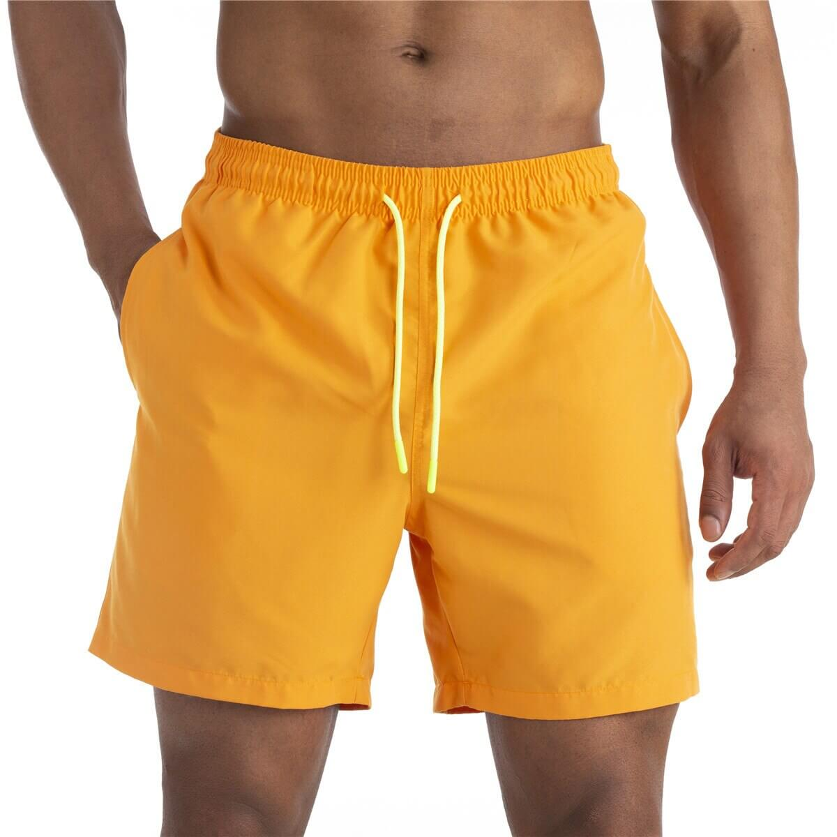 Men's solid color orange boardshorts with white drawstring, featuring pockets for swimwear versatility.
