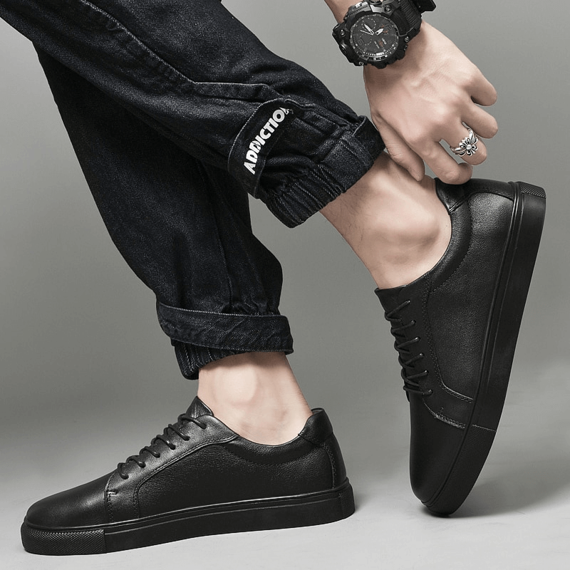 Men's black leather sports sneakers with flat sole, flexible and stylish design, worn with casual pants. Model SF1177.