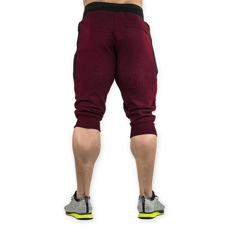 Back view of men's sports shorts with zippered pockets in maroon, ideal for running, featuring cotton and polyester for comfort and durability.