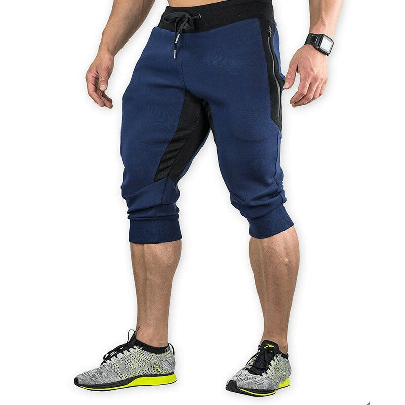 Men's sports shorts with zippered pockets, ideal for training and running, offering breathability and comfort. Cotton and polyester blend.