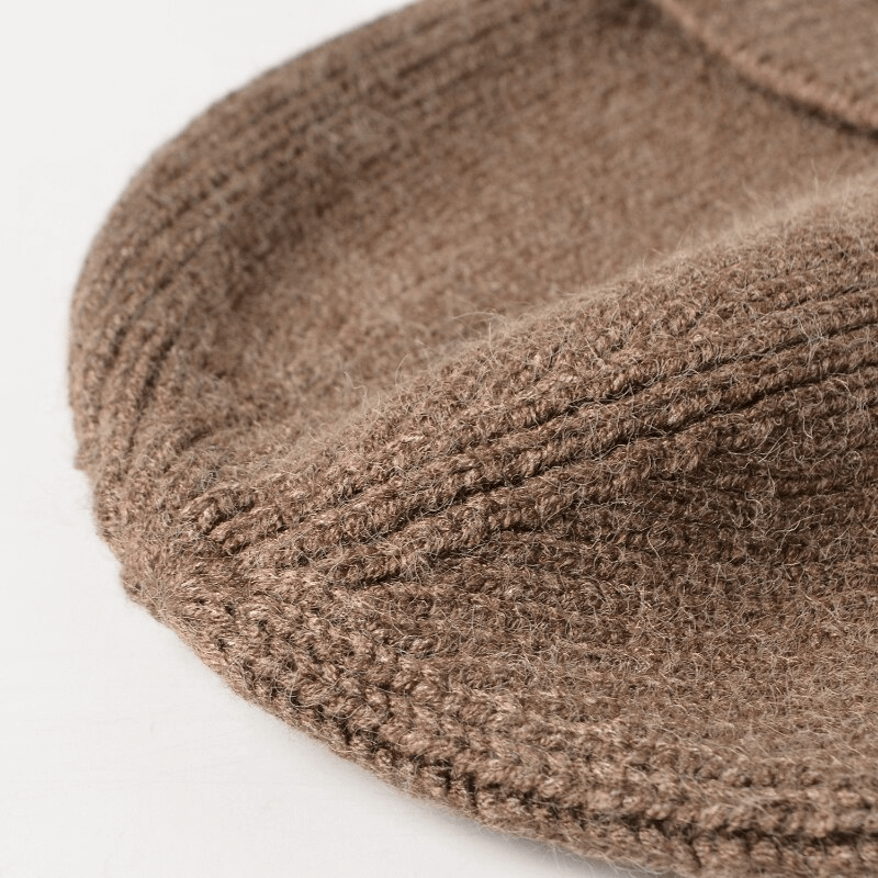 Close-up of a camel-colored knitted earflaps bonnet hat with textured design, perfect for warm sports running outdoors.