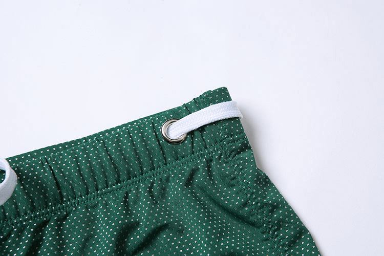 Green men's swimming boxers with white dots and adjustable drawstring for snug water fit.