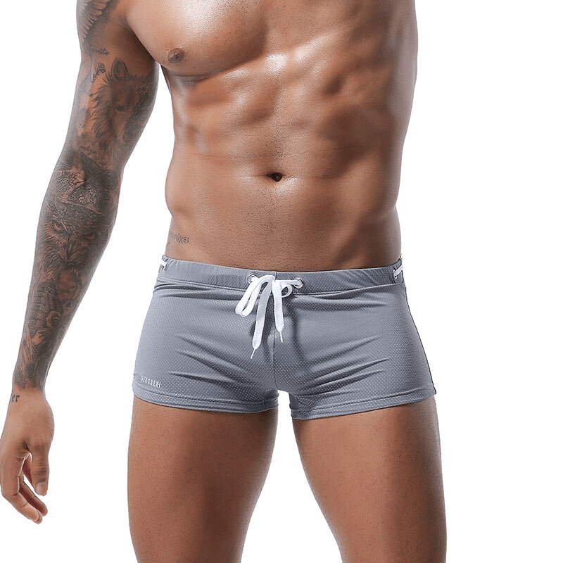 Men's swimming drawstring boxers in gray, designed for comfort and fit, showcasing a muscular physique.