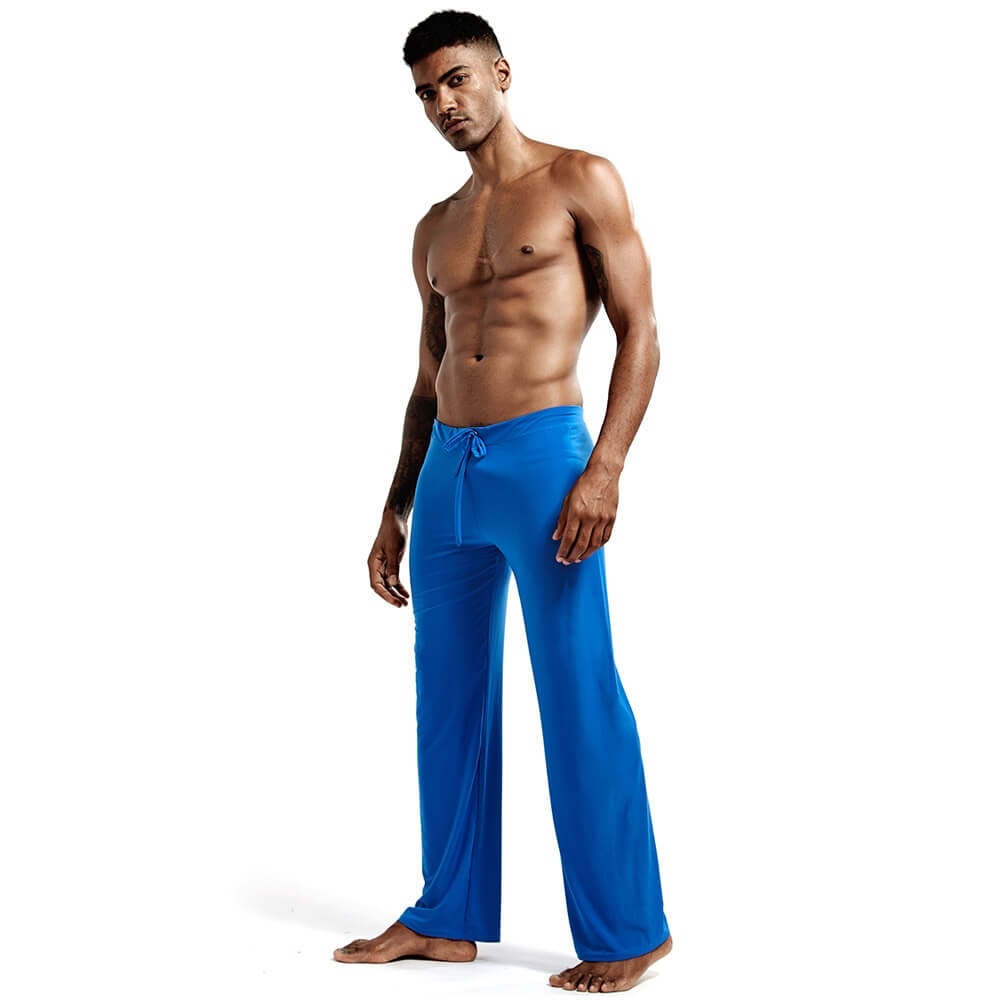 Model wearing blue men's yoga loose full-length pants for fitness, featuring drawstring closure and durable material blend.