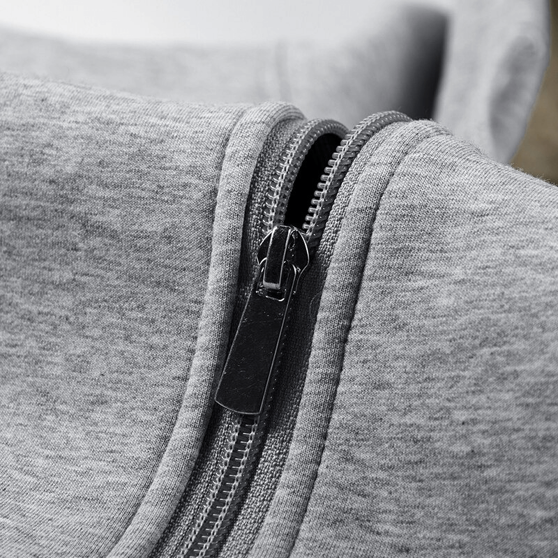 Close-up of the zipper on a men's grey thermal hoodie, showcasing fabric texture and craftsmanship.