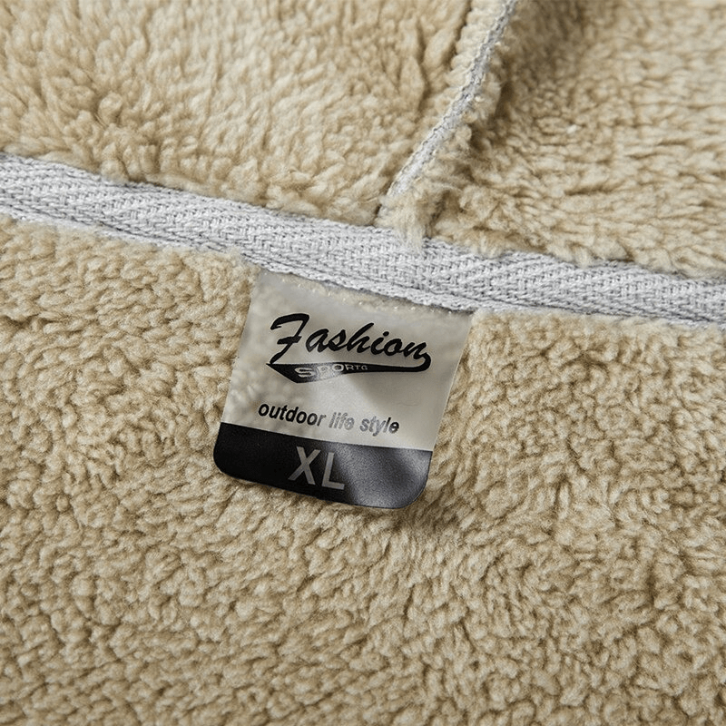 Close-up of fashion label in men's thick warm hoodie with fleece texture, displaying "XL" size and "outdoor lifestyle" text.