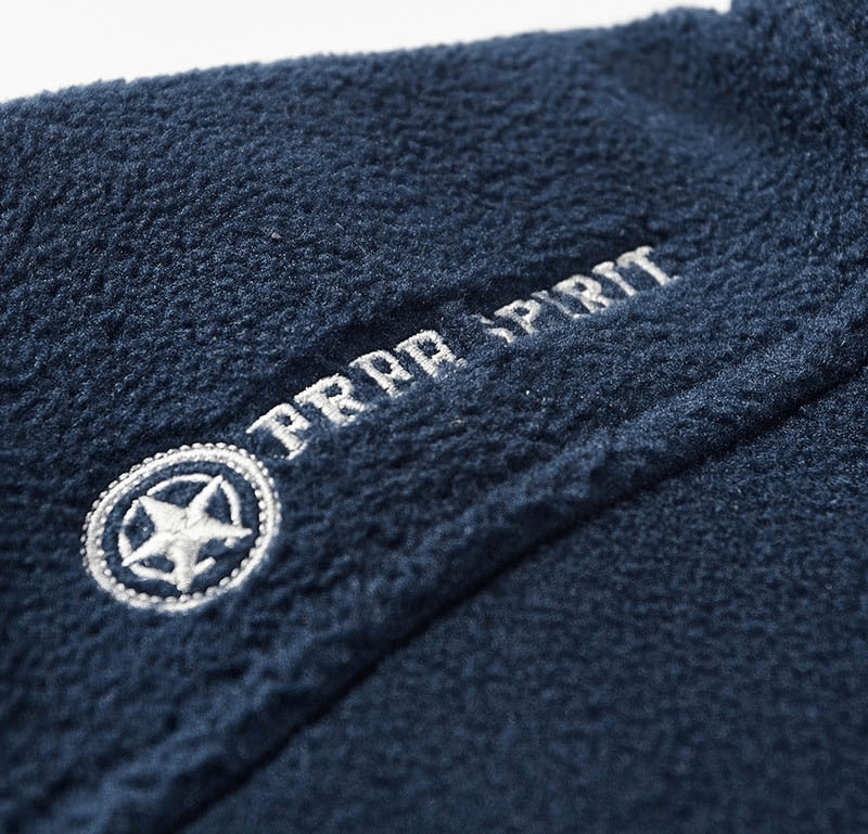Close-up of collar on men's fleece hiking jacket with 'Free Spirit' logo, featuring soft and warm blue fabric.