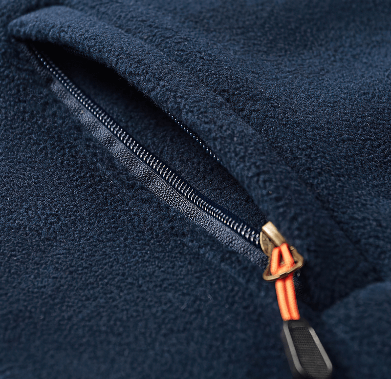 Close-up of navy fleece hiking jacket zipper detail, showcasing smooth texture and secure closure.