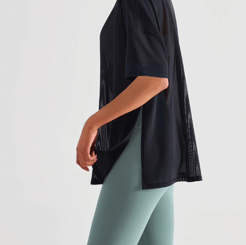 Woman wearing black Mesh Casual Sports T-Shirt, short sleeves, quick-drying fitness top, side view. Ideal for yoga and workouts.