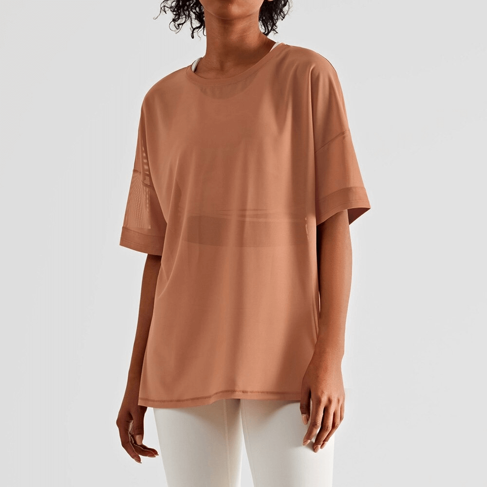 Woman wearing a mesh casual sports T-shirt with short sleeves, ideal for fitness enthusiasts. Lightweight, breathable, and quick-drying.