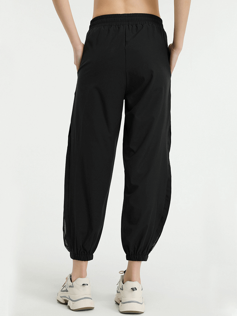 Back view of black mesh drawstring running trousers for women with elastic waistband, ideal for yoga and sports activities.
