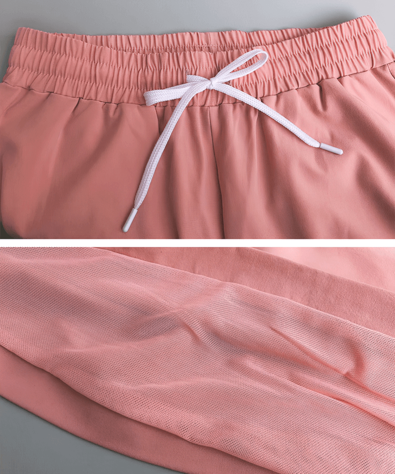 Close-up of pink mesh drawstring running trousers with elastic waistband and breathable material for comfort in workouts and yoga.