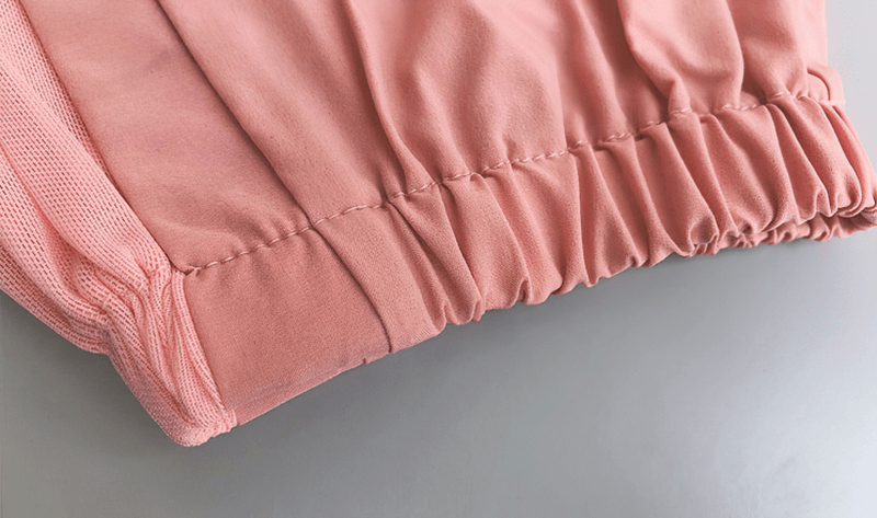 Close-up of pink mesh drawstring running trousers showing elastic waistband and durable stitching for comfort in yoga and sports.