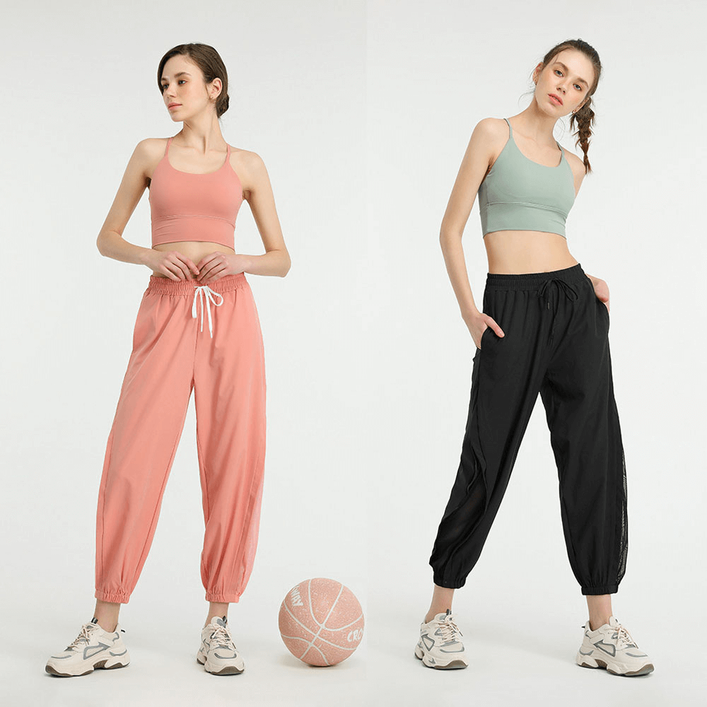 Two women wearing Mesh Drawstring Running Trousers in peach and black, ideal for yoga and sports activities.