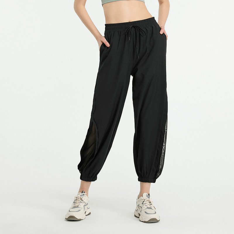 Woman wearing mesh drawstring running trousers, perfect for yoga and sports activities, featuring comfort and flexibility.