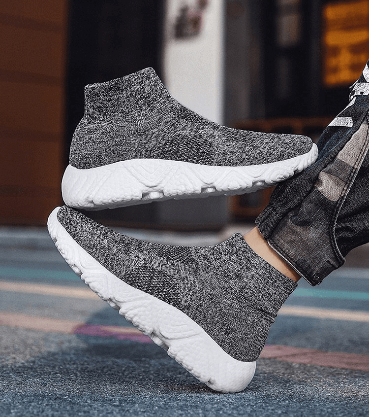 Mesh Elastic Breathable Unisex Sneakers with white soles, featuring air mesh for breathability and EVA cushioning, shown on pavement.