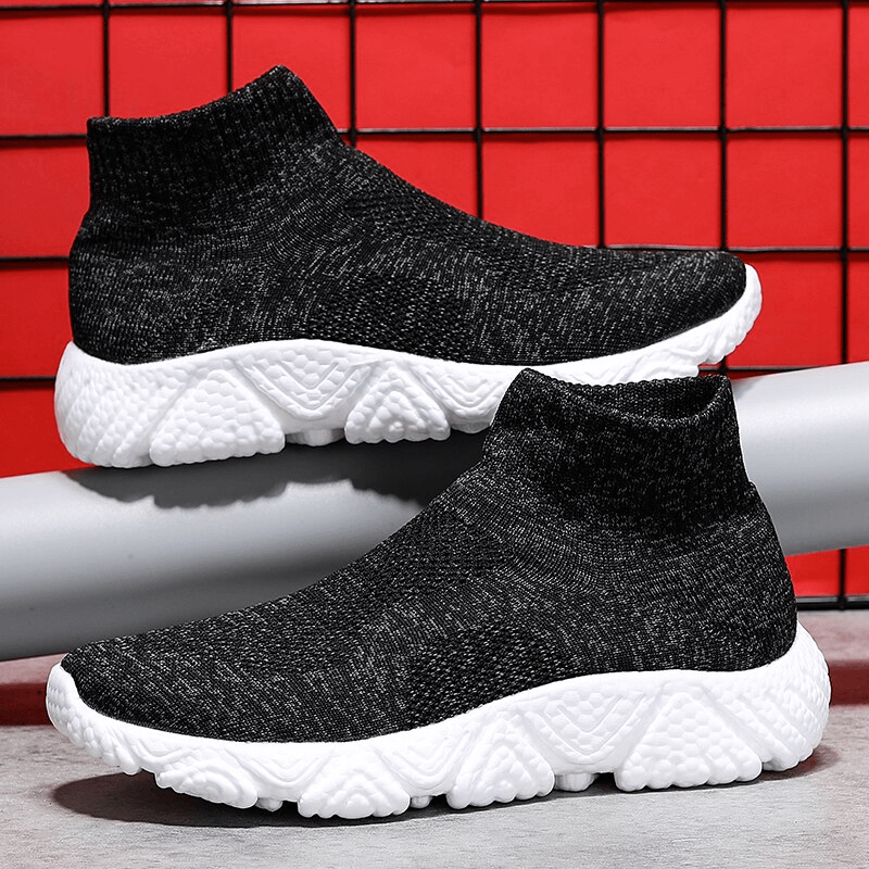 Black mesh elastic unisex sneakers with white soles, featuring breathable design and slip-on style against a red grid background.