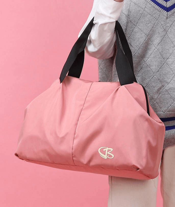 Sleek pink waterproof gym bag, designed for active women, with large capacity and durable black straps for fitness and travel.