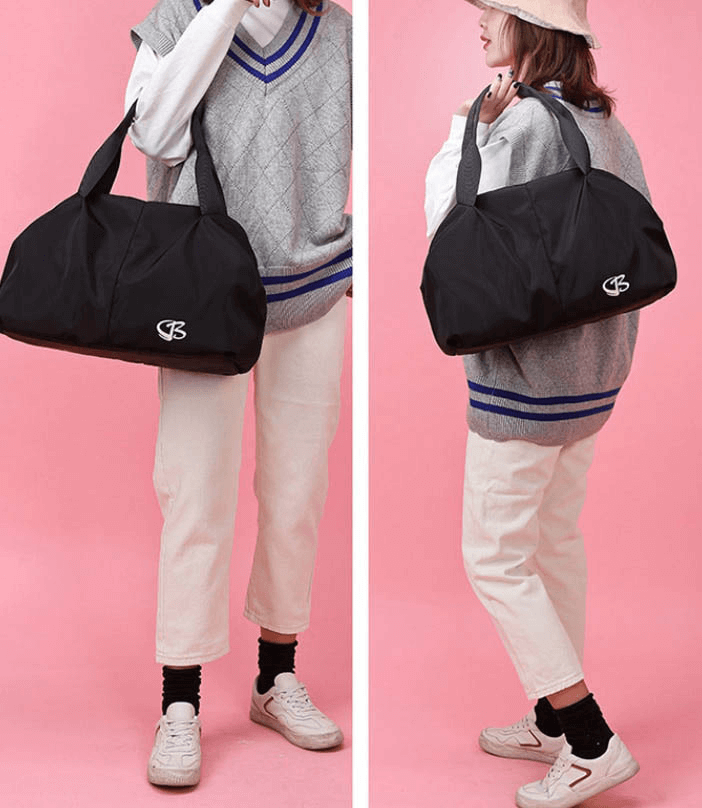 Two women holding a black SF0904 multifunction waterproof gym bag against a pink background, showcasing large capacity and stylish design.