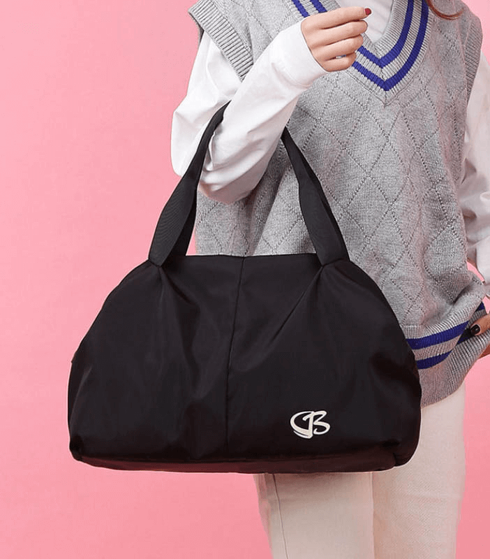 Stylish black multifunction waterproof women's large capacity gym bag with durable straps, perfect for sports and travel, being held.