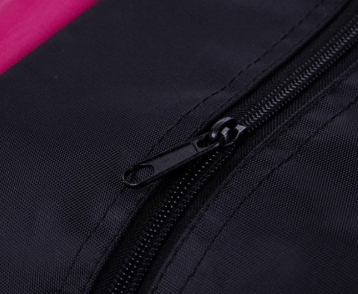Close-up of black zipper on pink and black waterproof sport women's bag, showcasing durable nylon material and craftsmanship.