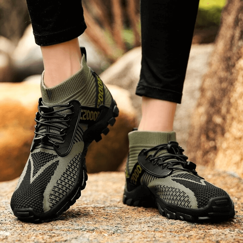 Unisex breathable trekking shoes with non-slip soles on rocky terrain, offering comfort and superior grip for outdoor adventures.