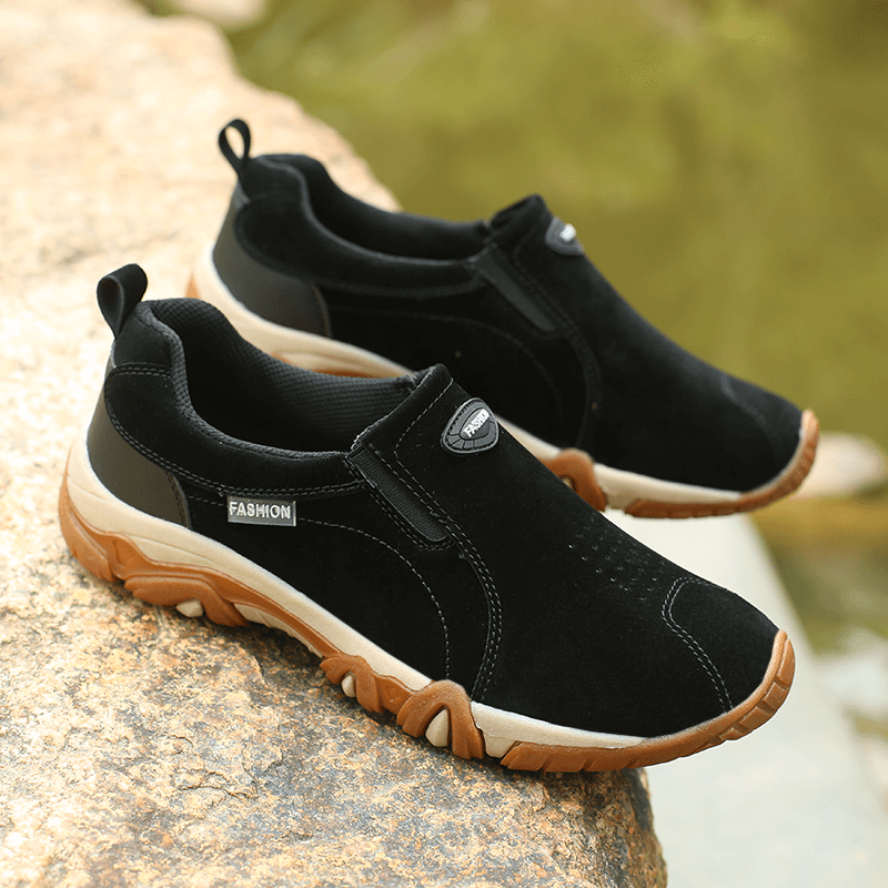 Alt Tag: Black non-slip outdoor hiking shoes for men SF1156 on a rocky surface, featuring durable rubber outsole for ultimate grip.