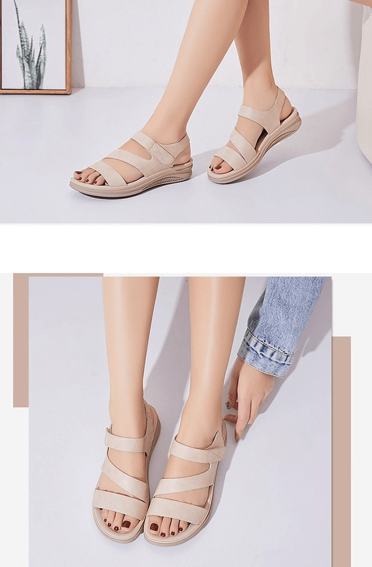 Woman wearing beige open light flexible wedge sandals with cross-straps and low heel, showcasing comfort and style for any occasion.