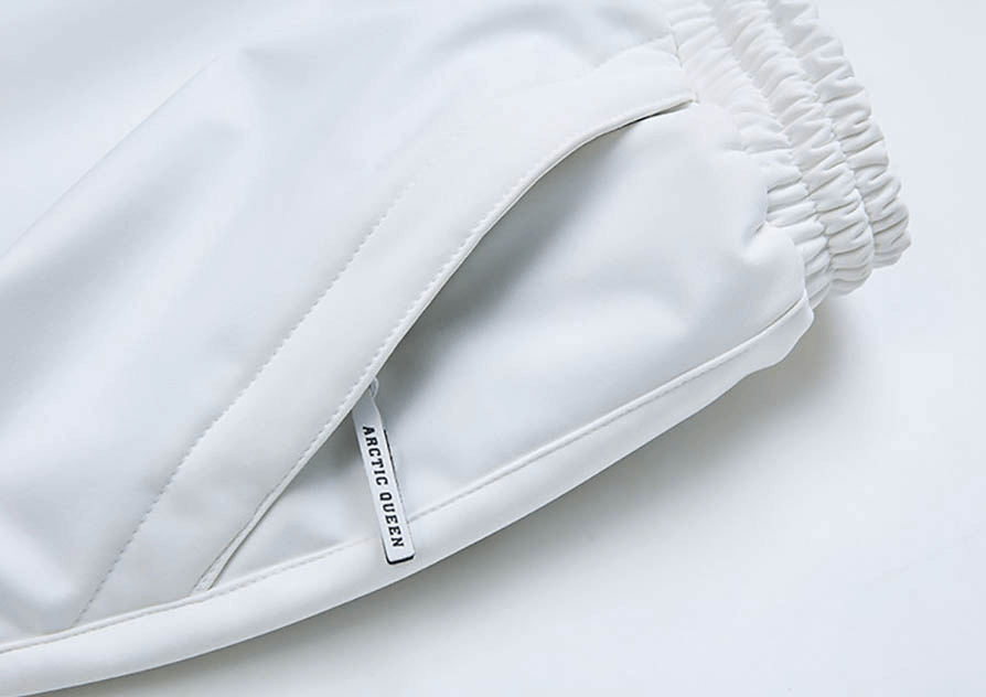 Close-up of white ski pants with elastic waistband, featuring a functional pocket for outdoor winter activities.