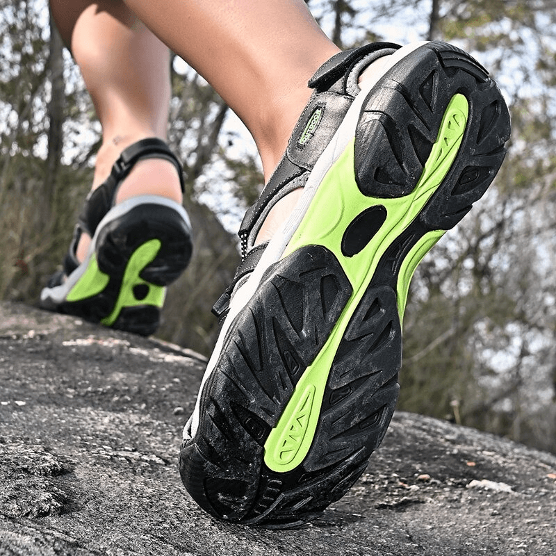 Close-up of Outdoor Genuine Leather Tactical Trekking Sandals for Men on rocky trail, showcasing rubber outsole and comfortable design. SF0669