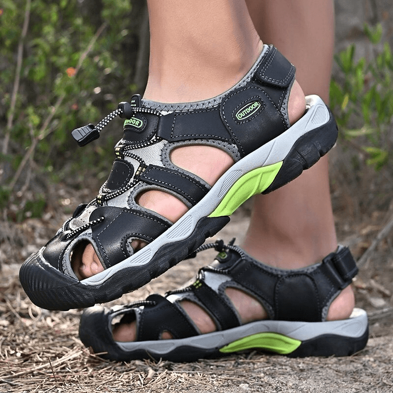 Men's outdoor genuine leather tactical trekking sandals on feet, featuring durable rubber soles and elastic band closure for comfort.