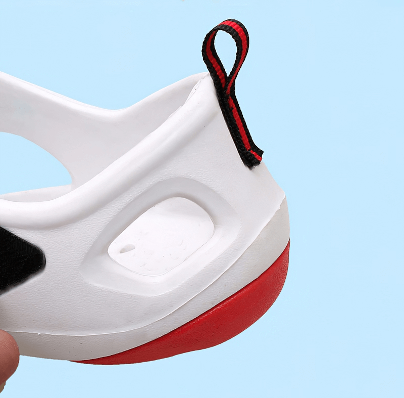 Close-up of men's water sandal with red sole and convenient hasp buckle on light blue background.