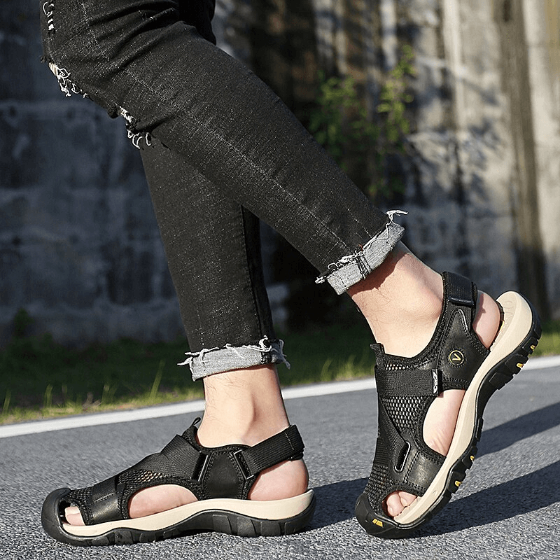 Person walking in outdoor mesh breathable sandals with Velcro closure on a path, showcasing comfort and grip.