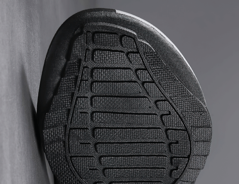 Close-up of black non-slip rubber outsole of men's beach flip flops with textured grip for outdoor traction, model SF0990.