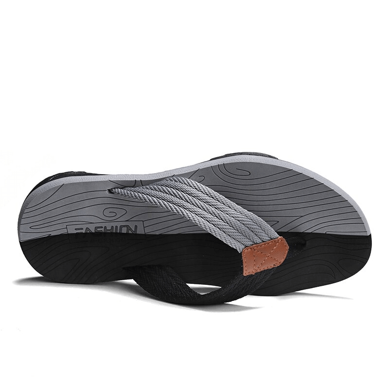 Bottom view of black and gray non-slip outdoor beach flip flops for men with thick outsole and stylish design.