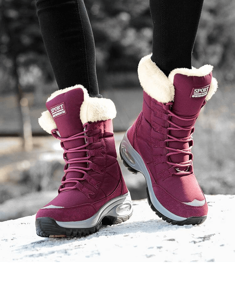 Warm waterproof women's snow boots in magenta with fur lining, ideal for winter trekking, showcasing traction-ready rubber outsole.