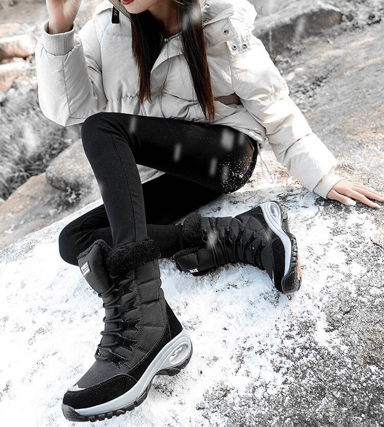Woman wearing black outdoor snow boots on snowy terrain, showcasing SF0288 waterproof trekking shoes with rubber sole and warm lining.