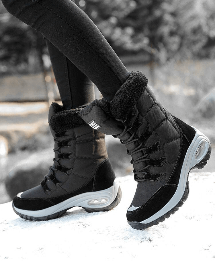 Woman wearing black waterproof snow boots for winter trekking on icy terrain, featuring fur lining and rubber sole, style SF0288.