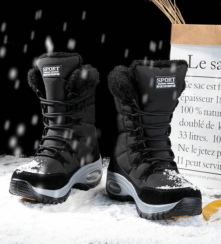 Black waterproof women's snow boots with fur lining and rubber soles, perfect for winter trekking on snowy terrain.