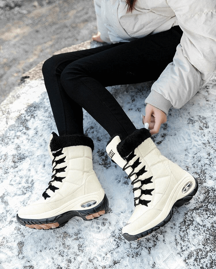Woman wearing white waterproof snow boots on snowy surface showcasing outdoor winter footwear for trekking, model SF0288.