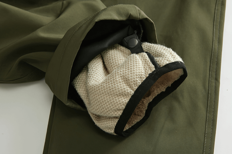 Close-up of windproof ski pants with removable liner, showcasing durable polyester fabric and warm, detachable inner lining, perfect for winter.
