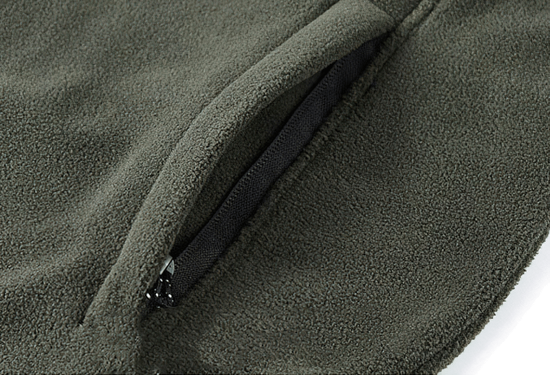 Close-up of green outdoor zipper fleece hiking jacket with inside pocket, ideal for men's winter comfort and warmth.