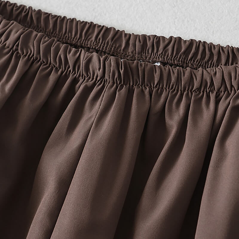 Close-up of elastic waistband on brown oversized high-waisted sweatpants for women, showcasing breathable woven polyester fabric.